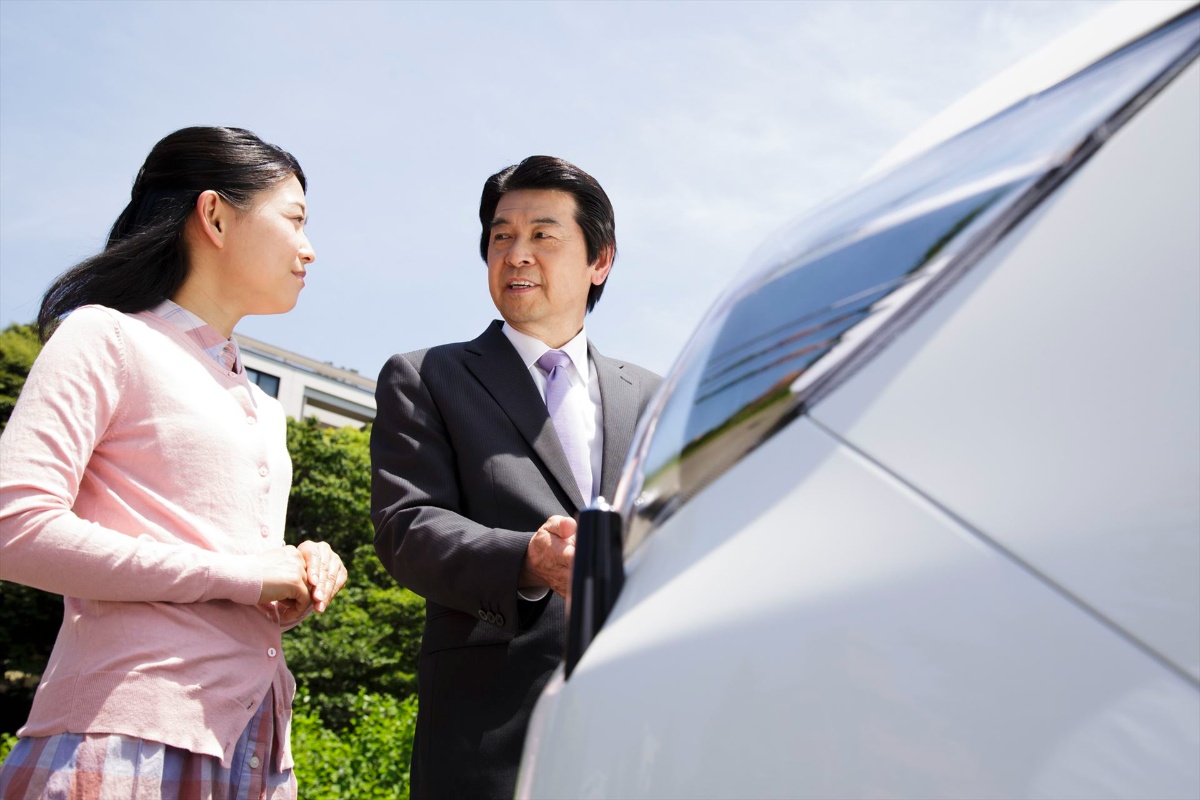 顧客に車を紹介するスタッフ